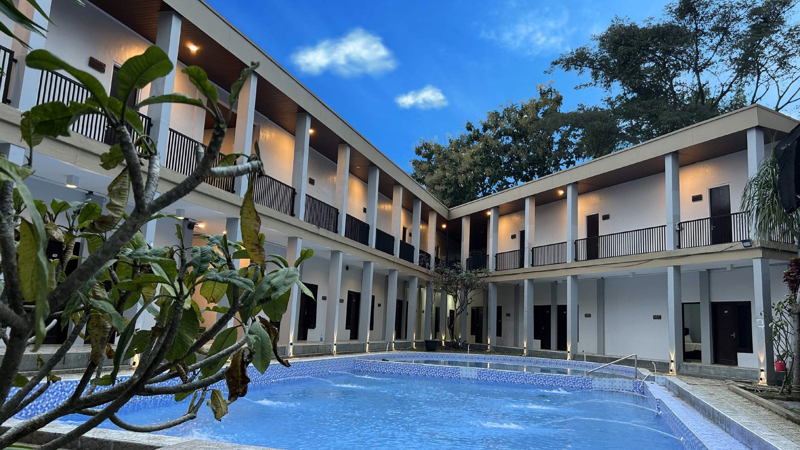Kolam renang outdoor Bwalk Hotel dikelilingi bangunan kamar dua lantai